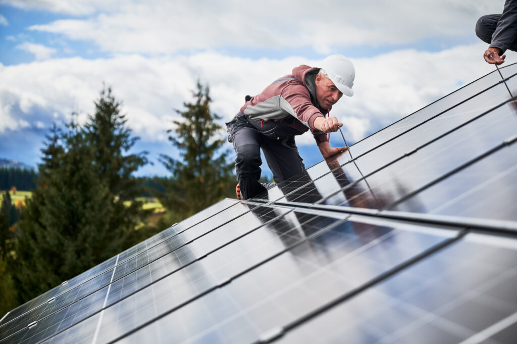 Technician on a roof installing solar panels